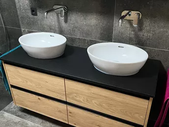 Doppelwaschbecken in Eiche mit schwarzer Auflagefläche und aufgesetzten Porzellanwaschbecken